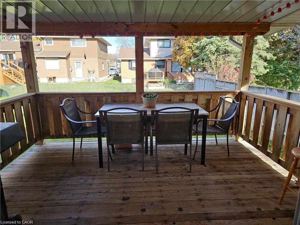 Covered wood deck with slatted wood railings and a translucent overhead panel - 66 Summit Avenue, Kitchener, ON - With Deck Patio Veranda With Exterior