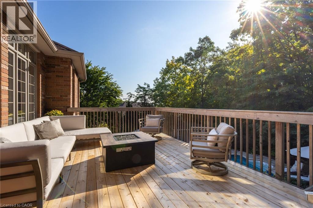 Spacious outdoor deck featuring natural wood flooring and a fire pit - 1285 Beaufort Drive, Burlington, ON