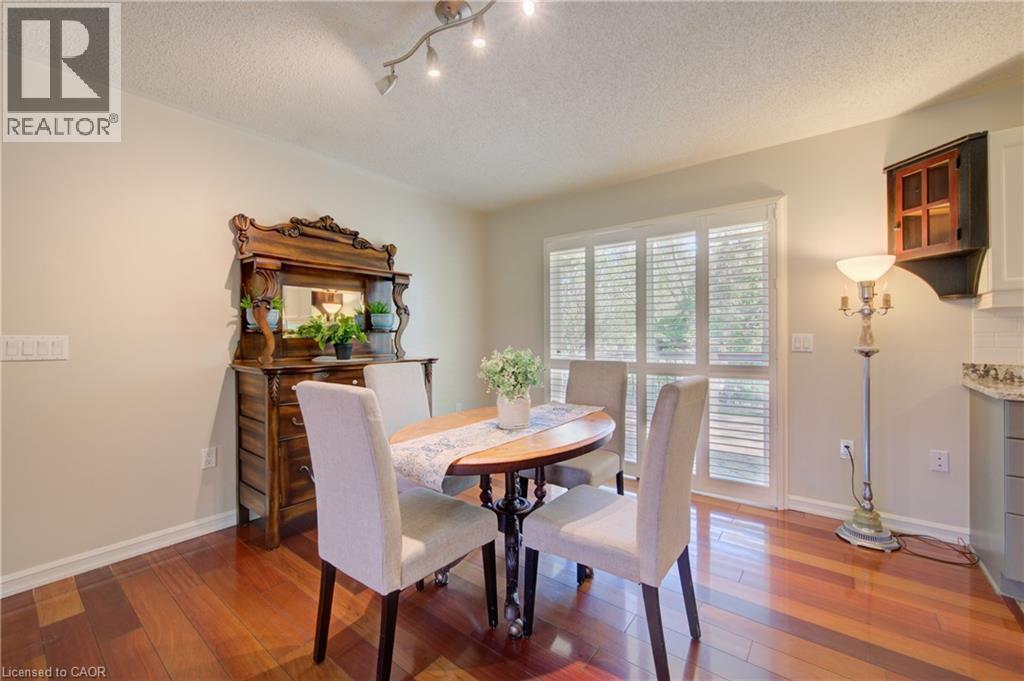 Hardwood flooring featuring an adjacent glass-paneled door with plantation shutters and a track lighting fixture - 137 Wesley Crescent, Waterloo, ON