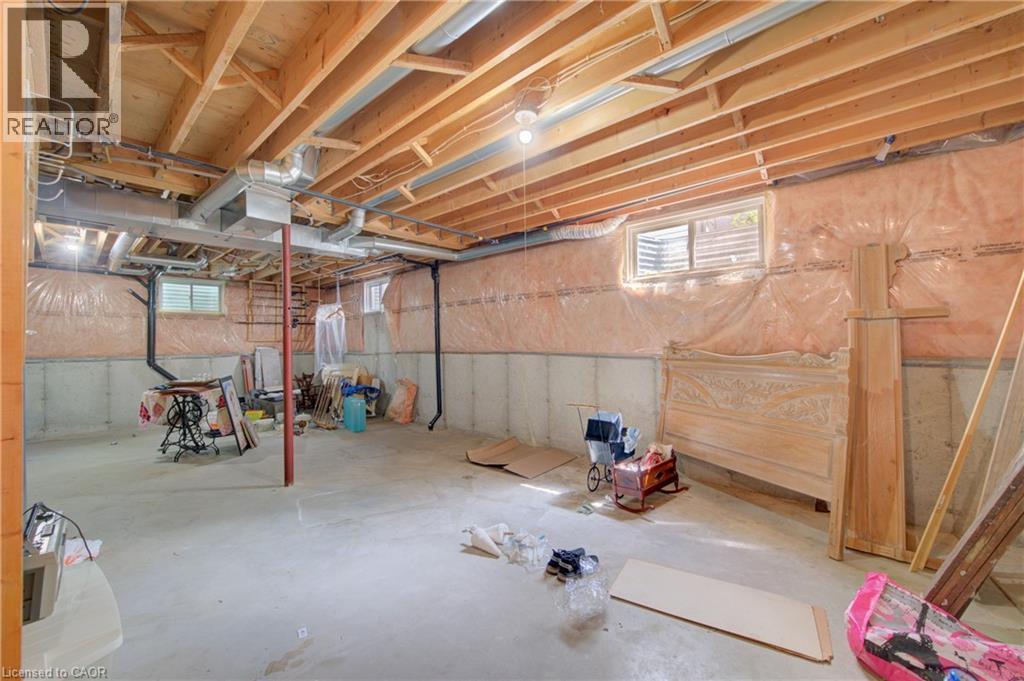Spacious unfinished basement offering exposed wood joists and concrete flooring - 137 Wesley Crescent, Waterloo, ON
