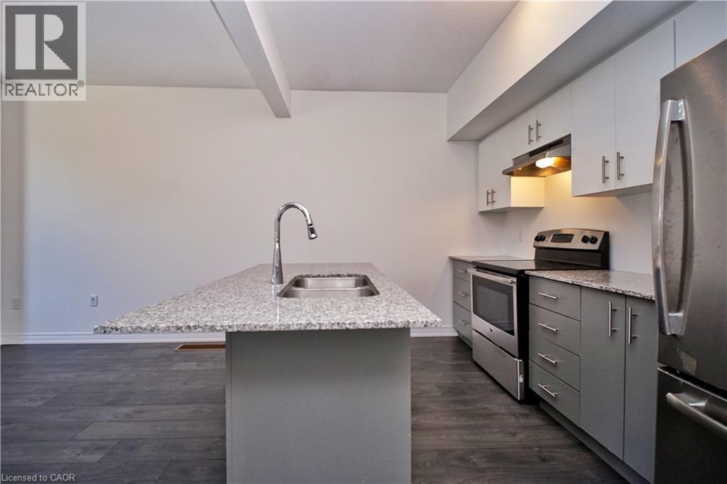 Modern kitchen featuring a central island with a sink and a high-arc faucet, granite countertops, and stainless steel appliances - 10 Birmingham Drive Unit# 129, Cambridge, ON - Indoor Photo Showing Kitchen With Stainless Steel Kitchen With Double Sink With Upgraded Kitchen