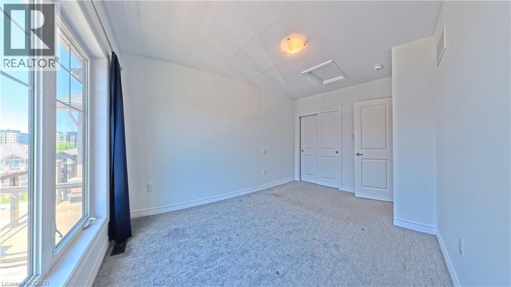 Bright room with broadloom carpeting, a multi-pane window, and white trim - 10 Birmingham Drive Unit# 129, Cambridge, ON - Indoor Photo Showing Other Room