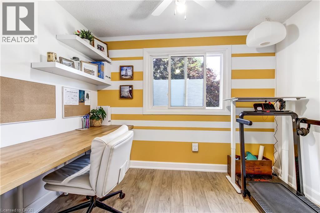 Dedicated space featuring wood-finish flooring, a built-in desk, and two floating shelves - 218 Richardson Drive Unit# 26, Port Dover, ON