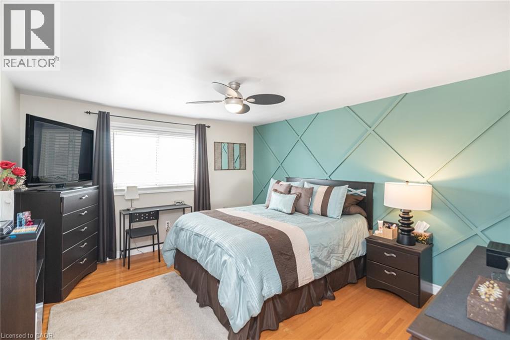 Feature wall with geometric paneling and a ceiling fan with integrated lighting - 366 Berkindale Drive, Hamilton, ON
