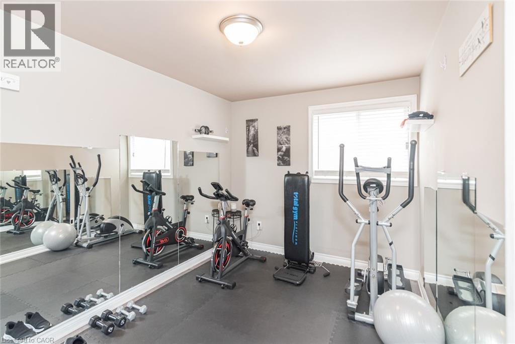 Dedicated exercise room featuring wall-to-wall mirrors, a window with blinds, and recessed lighting - 366 Berkindale Drive, Hamilton, ON