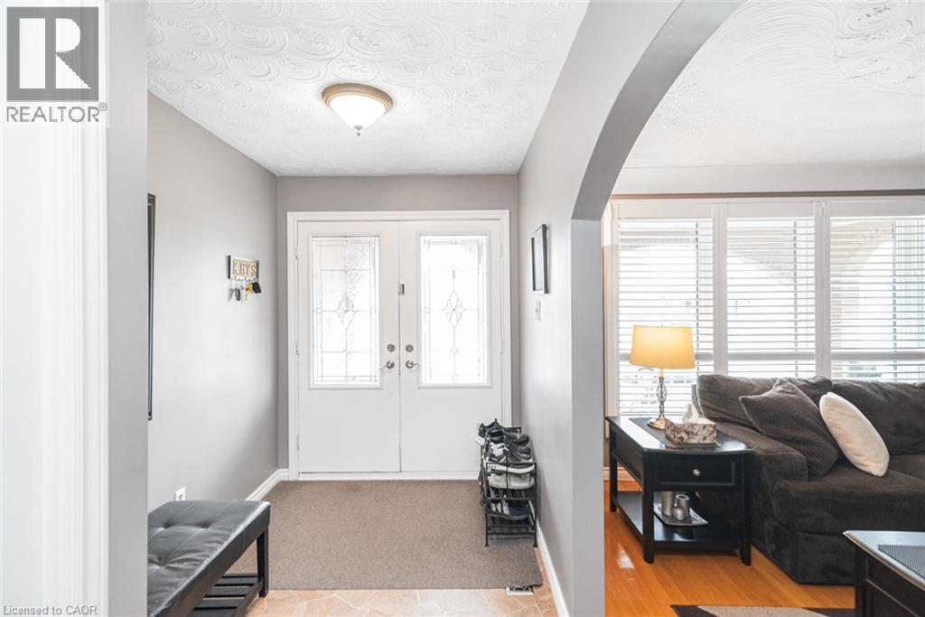 Entry foyer featuring double white entry doors with decorative glass panels, a semi-flush mount ceiling fixture, and neutral wall paint - 366 Berkindale Drive, Hamilton, ON
