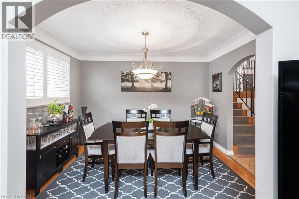 Formal dining area featuring a decorative ceiling medallion, arched doorway, and hardwood-finish flooring - 366 Berkindale Drive, Hamilton, ON