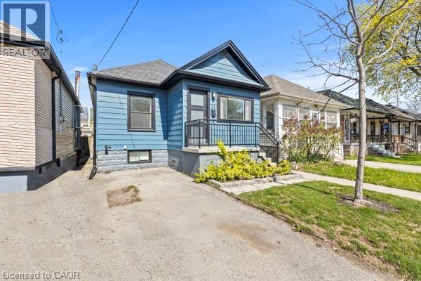 Blue siding exterior with contrasting black trim - 33 Huxley Avenue N, Hamilton, ON