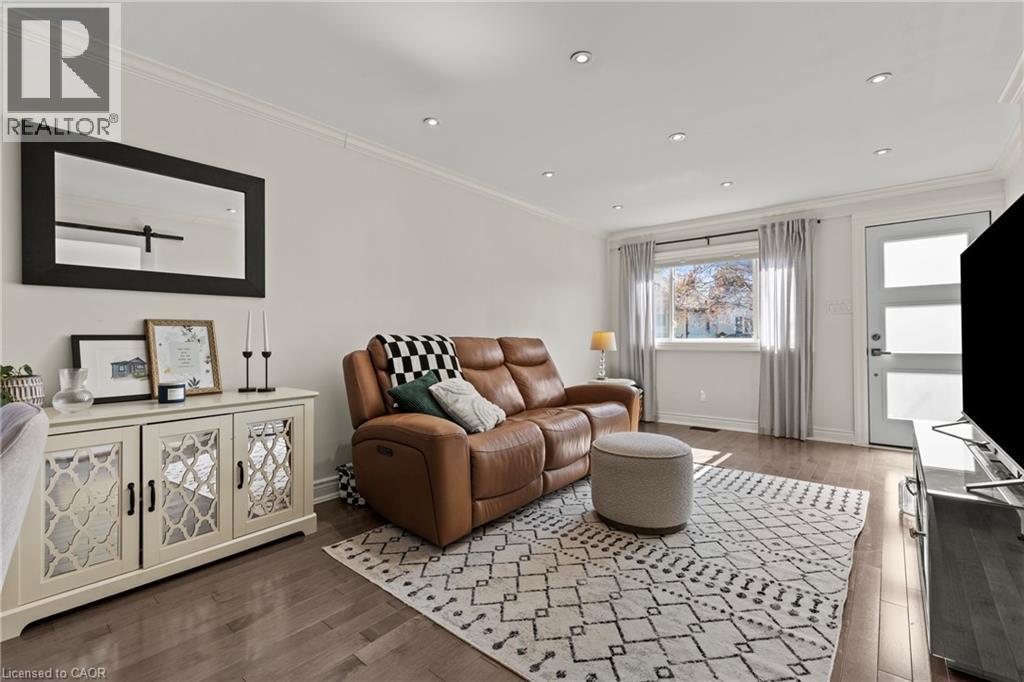 Recessed lighting, crown molding, and wood-finish flooring enhance this living space - 33 Huxley Avenue N, Hamilton, ON