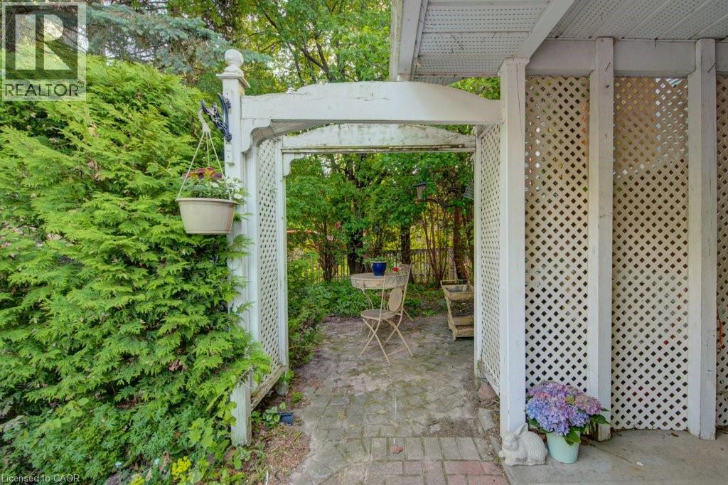 White lattice archway opening to a paver patio - 60 Mayfield Avenue, Waterloo, ON