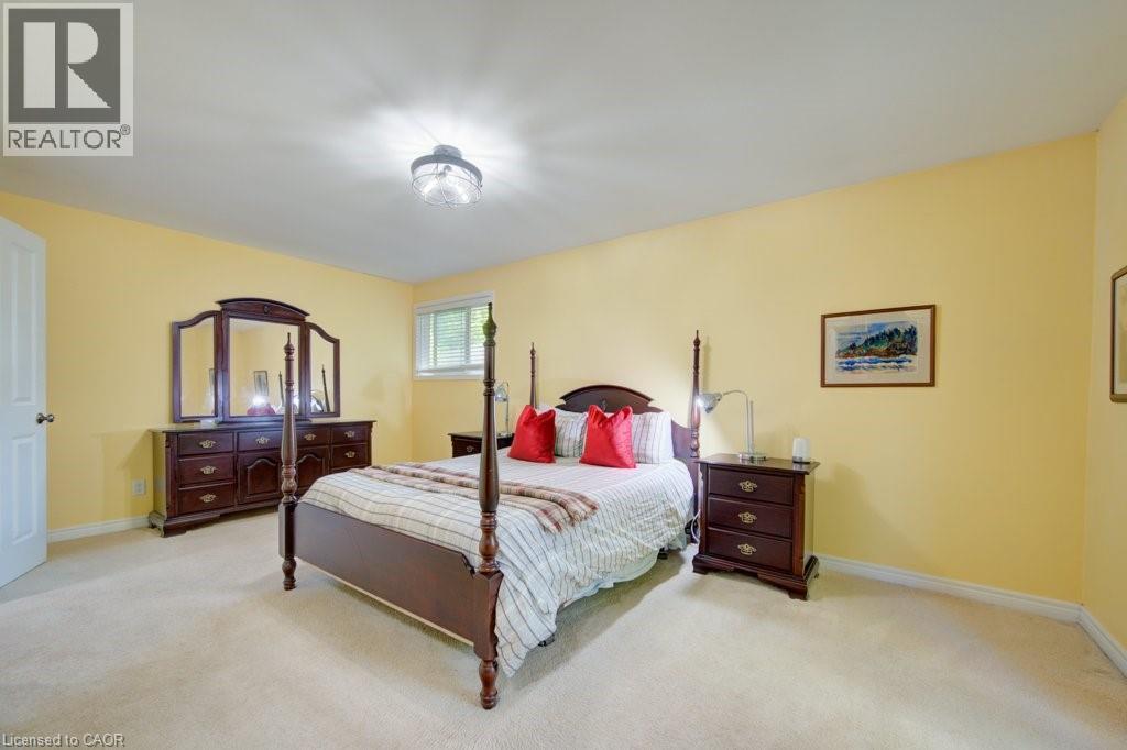 Carpeted room featuring a white door, a single window with blinds, and a ceiling-mounted light fixture - 60 Mayfield Avenue, Waterloo, ON
