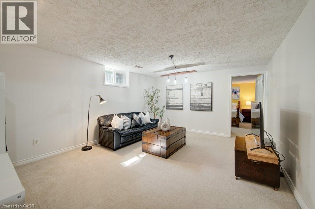 Carpeted living space featuring recessed window, a flush-mounted light fixture, and white baseboards - 60 Mayfield Avenue, Waterloo, ON