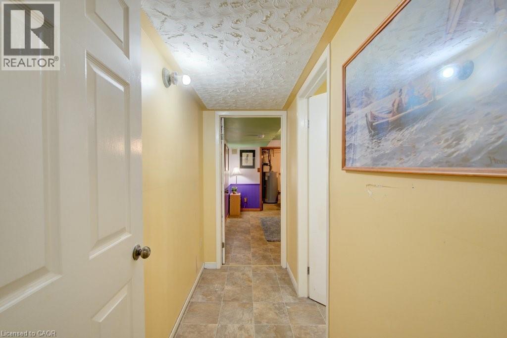 Interior hallway featuring wood-finish flooring, light yellow walls, and a textured ceiling - 60 Mayfield Avenue, Waterloo, ON