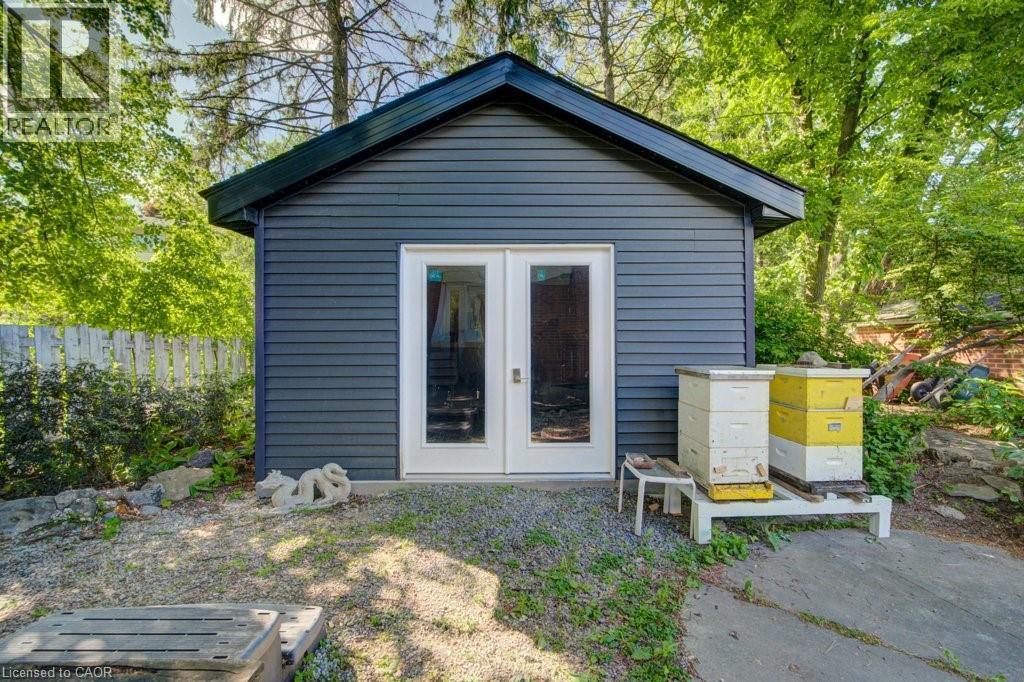 Detached outbuilding with dark siding and a contrasting dark roofline - 60 Mayfield Avenue, Waterloo, ON