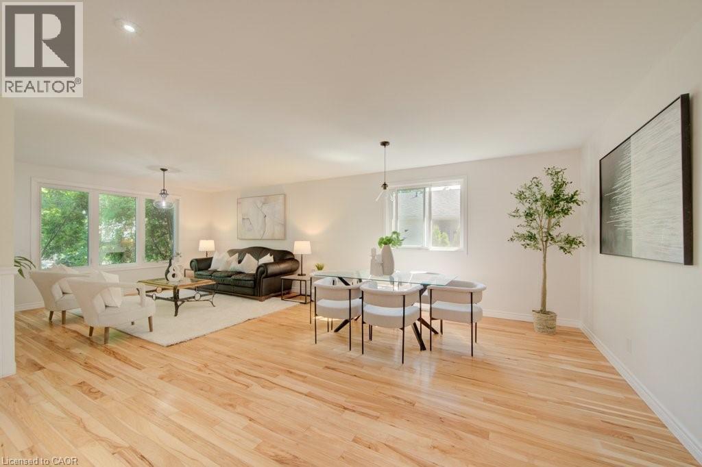 Spacious open-concept living area featuring light wood-finish flooring, white walls, and recessed lighting - 60 Mayfield Avenue, Waterloo, ON