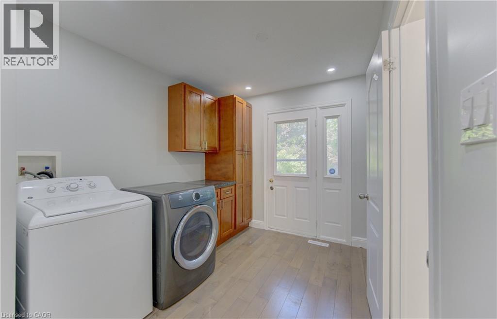 Laundry area featuring wood-finish flooring, recessed lighting, and a double-door exterior entry with clear glass panels - 80 Lower Canada Crescent, Kitchener, ON