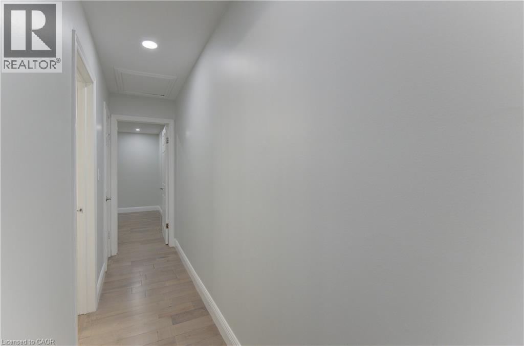 Hallway featuring light wood-finish flooring, recessed lighting, and crisp white baseboards - 80 Lower Canada Crescent, Kitchener, ON