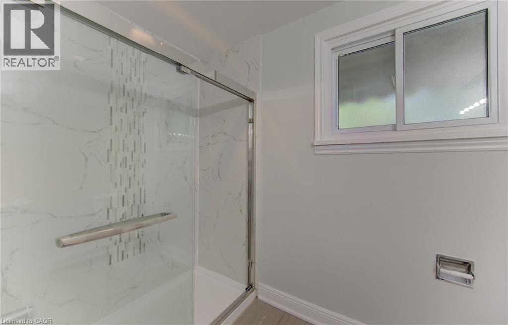 Enclosed shower with clear glass sliding door featuring a brushed metal handle - 80 Lower Canada Crescent, Kitchener, ON