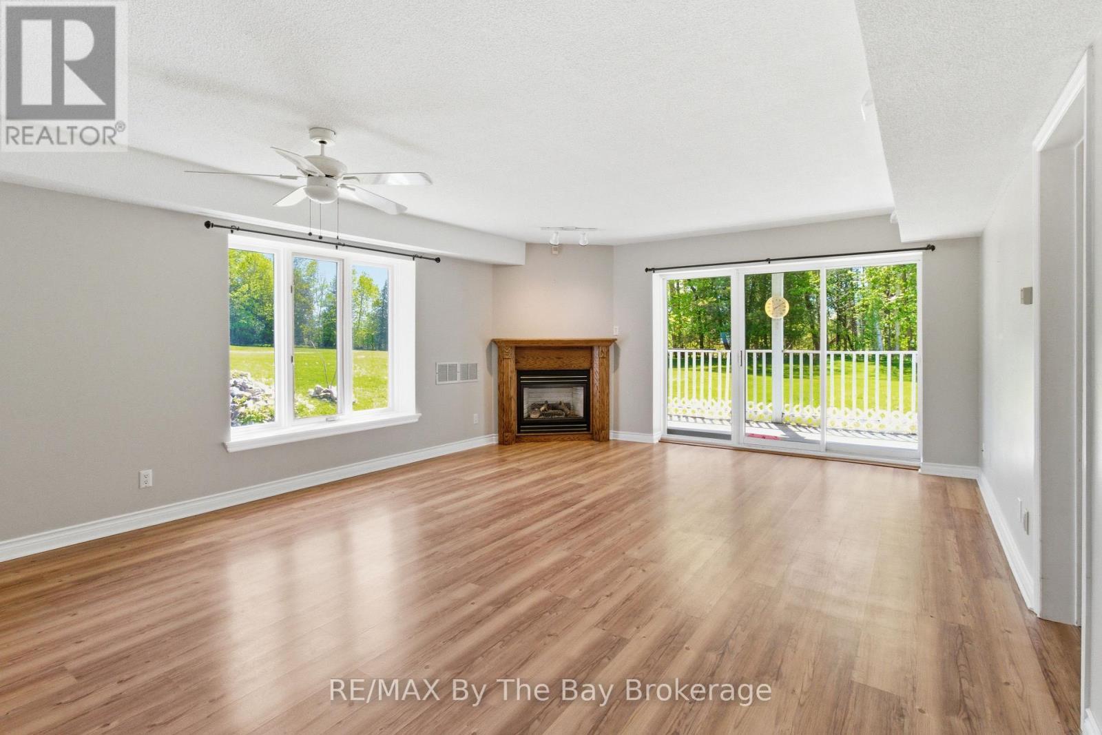 living room, gas f/p walkout - 1 - 10 Mulligan Lane, Wasaga Beach, ON - Indoor Photo Showing Living Room With Fireplace