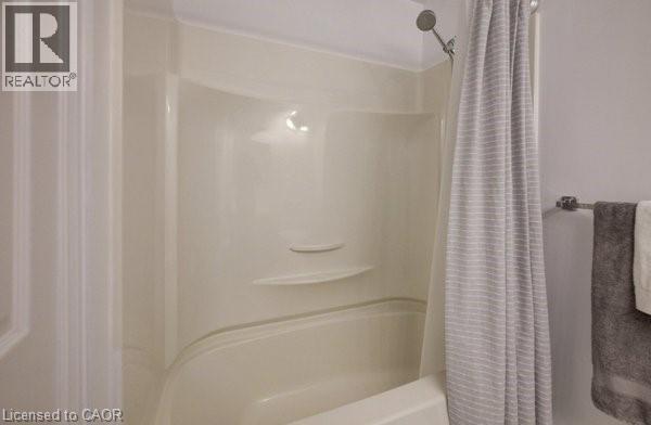 Bedroom featuring dark wood-finish flooring, light neutral wall paint, and white baseboards - 4 Ronald Road, Cambridge, ON