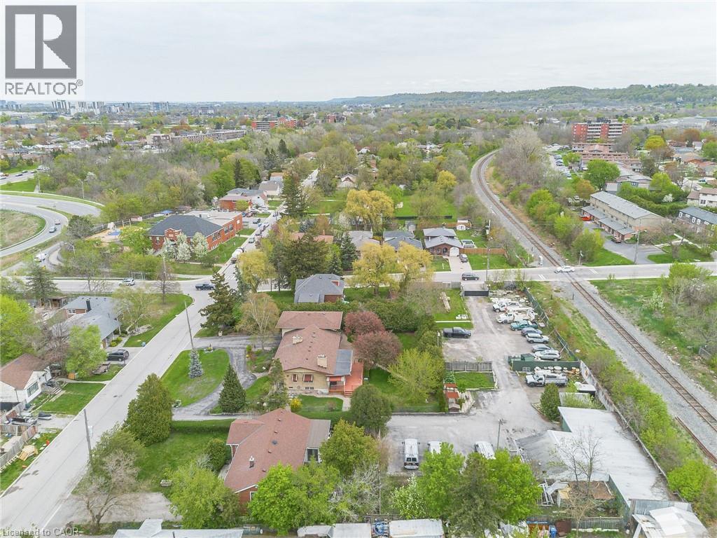 Aerial perspective showcasing a mixed-use area with residential properties, commercial lots, and a railway line - 262-270-276 Hixon Road, Hamilton, ON