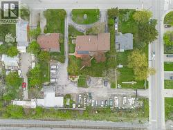 Extensive property featuring multiple structures, paved parking areas, and mature trees -