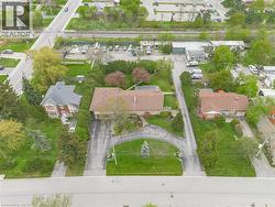 Spacious property featuring multiple structures, mature trees, and extensive paved driveways -