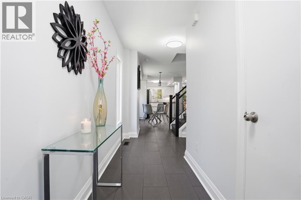 Entrance hallway featuring dark tile flooring, white baseboards, and a white interior door with brushed nickel hardware - 7 Upper Mercer Street Unit# G30, Kitchener, ON - Indoor Photo Showing Other Room