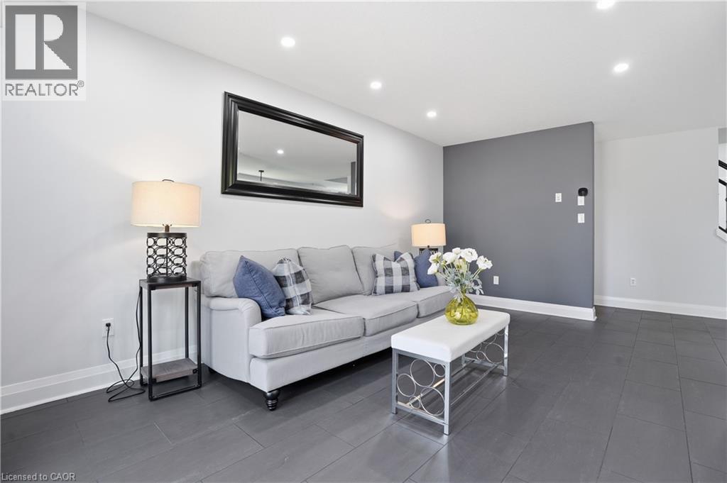 Living area featuring recessed lighting, a statement accent wall, white baseboards, and dark wood-finish flooring - 7 Upper Mercer Street Unit# G30, Kitchener, ON - Indoor Photo Showing Living Room