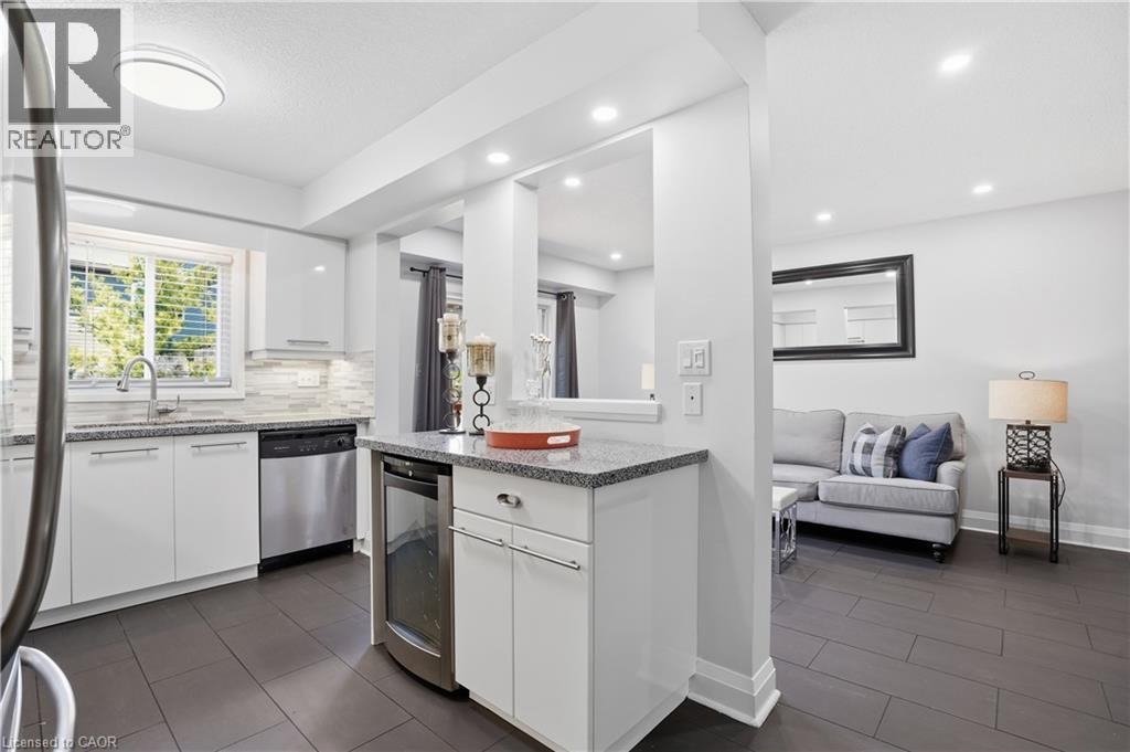 Kitchen featuring white cabinetry, stainless steel appliances, granite countertops, and a tile backsplash - 7 Upper Mercer Street Unit# G30, Kitchener, ON - Indoor Photo Showing Kitchen With Upgraded Kitchen