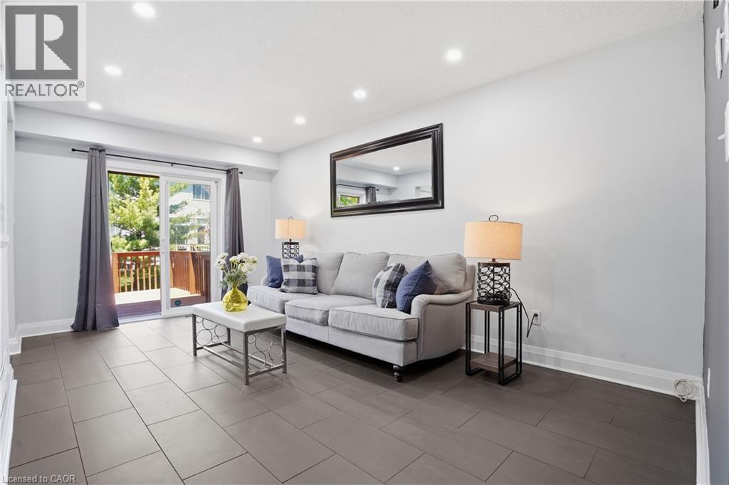Spacious room featuring large format tile flooring, recessed lighting, and a glass sliding door opening to an outdoor deck - 7 Upper Mercer Street Unit# G30, Kitchener, ON - Indoor Photo Showing Living Room