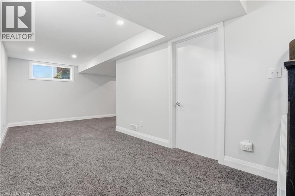 Spacious finished room featuring grey carpeting, recessed lighting, and a white interior door - 7 Upper Mercer Street Unit# G30, Kitchener, ON - Indoor