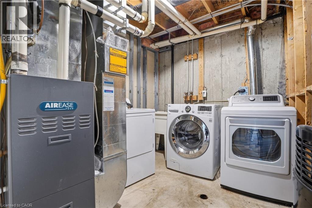 Dedicated laundry area featuring a front-load washer, a front-load dryer, and a utility sink - 7 Upper Mercer Street Unit# G30, Kitchener, ON - Indoor Photo Showing Laundry Room