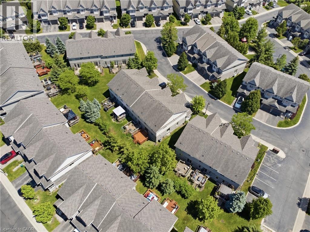 Aerial overview of a residential community featuring multiple multi-story buildings with grey shingle roofs - 7 Upper Mercer Street Unit# G30, Kitchener, ON - Outdoor With View