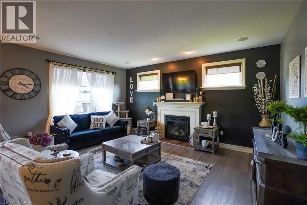 Living area featuring wood-finish flooring, a white mantel fireplace, and recessed ceiling lighting - 365 Poldon Drive, Norwich, ON