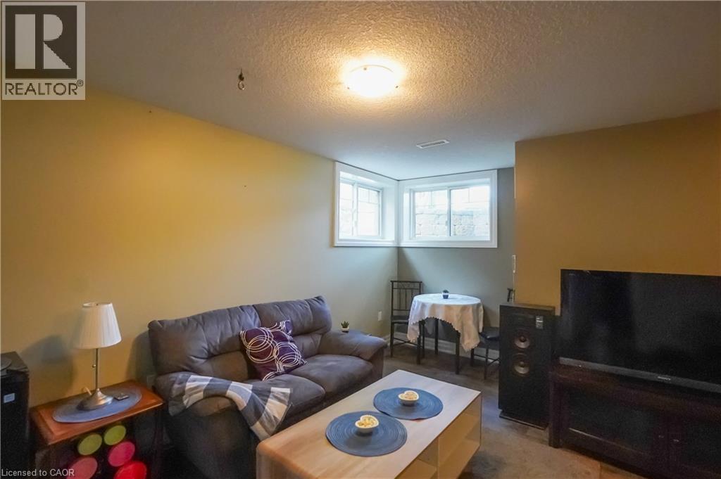 Lower level room with two windows and a flush mount ceiling light - 365 Poldon Drive, Norwich, ON