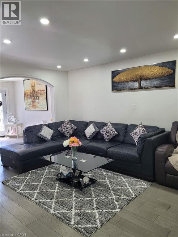 Recessed lighting illuminates this living space featuring wood-finish flooring and a white wall finish - 153 Arnold Street, Kitchener, ON