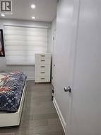 Room featuring wood-finish flooring, recessed lighting, and a window with horizontal blinds -