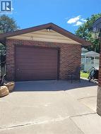 Detached brick garage with a pitched roof and a brown panel garage door -