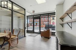 Interior retail space featuring front-facing glass storefront, wood-finish flooring, and recessed lighting -
