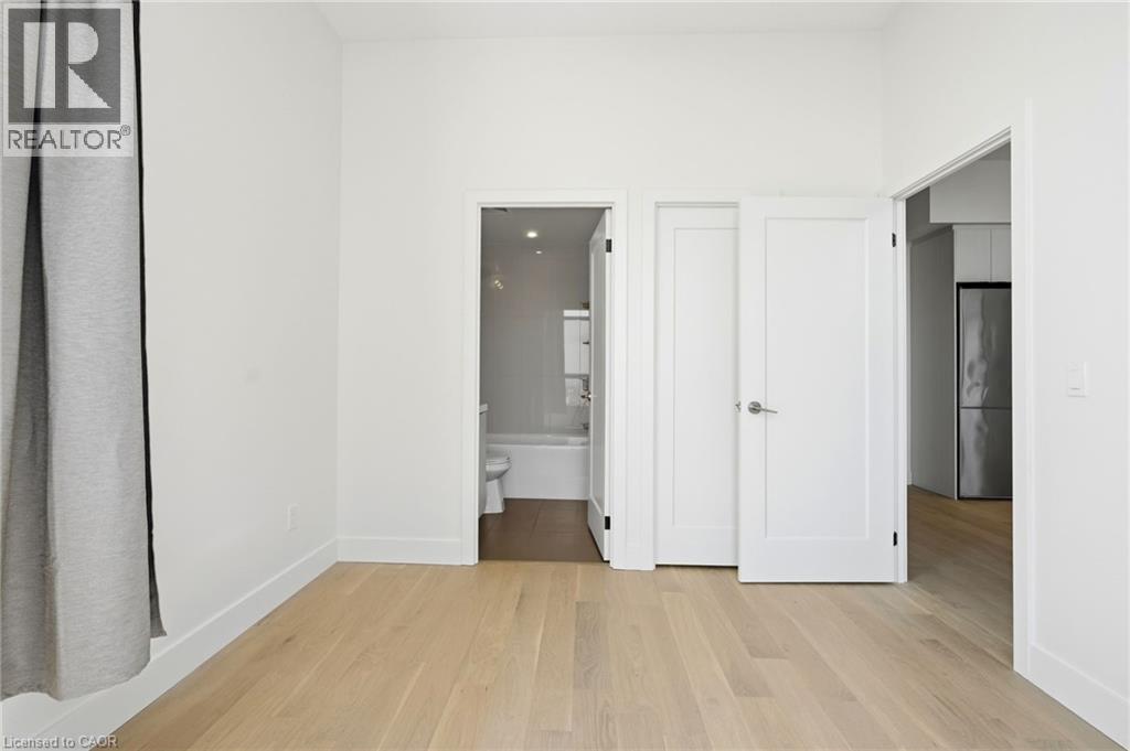 Light wood-finish flooring complements crisp white walls and baseboards - 7 Mabelle Avenue Unit# Ph07, Toronto, ON