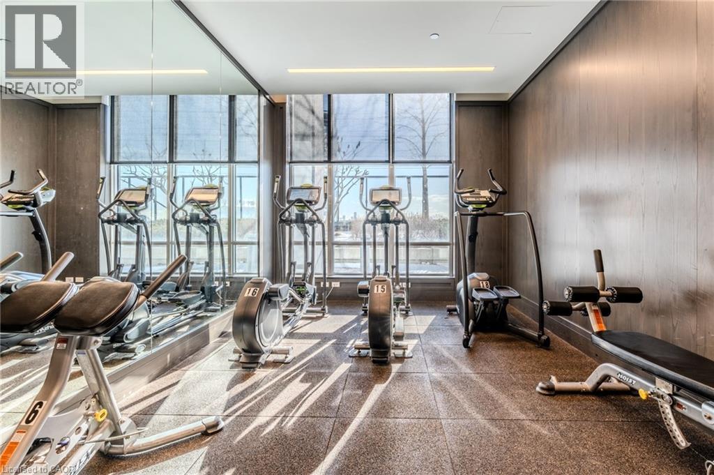 Fitness center featuring floor-to-ceiling windows, wood-finish wall panels, recessed lighting, and resilient flooring - 7 Mabelle Avenue Unit# Ph07, Toronto, ON