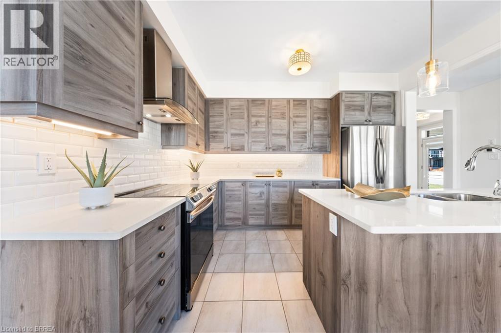 Kitchen featuring modern cabinets, light tile patterned flooring, electric stove, wall chimney range hood, and tasteful backsplash - 1 Bee Crescent, Brantford, ON