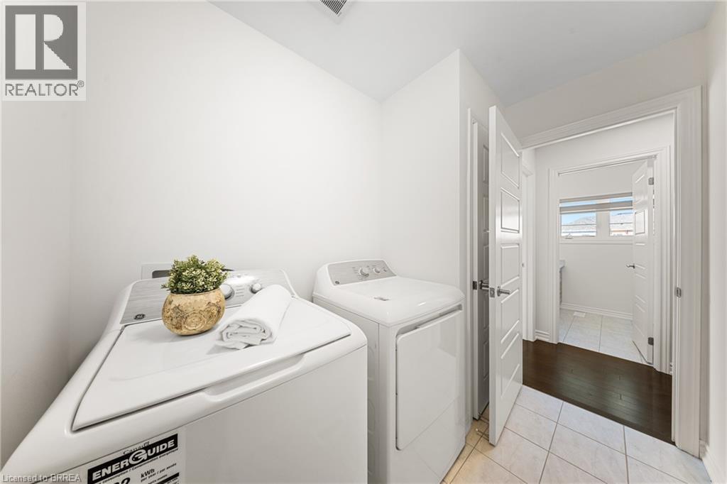 Washroom featuring light tile patterned flooring and independent washer and dryer - 1 Bee Crescent, Brantford, ON