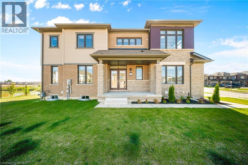 Rear view of property featuring covered porch, a yard, brick siding, and french doors - 1 Bee Crescent, Brantford, ON