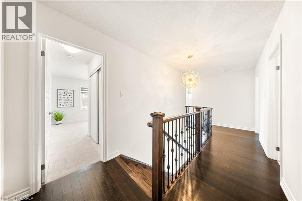 Hallway featuring an upstairs landing, dark wood finished floors, and a chandelier - 1 Bee Crescent, Brantford, ON