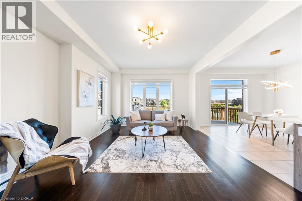 Living room featuring a chandelier, healthy amount of natural light, and wood finished floors - 1 Bee Crescent, Brantford, ON