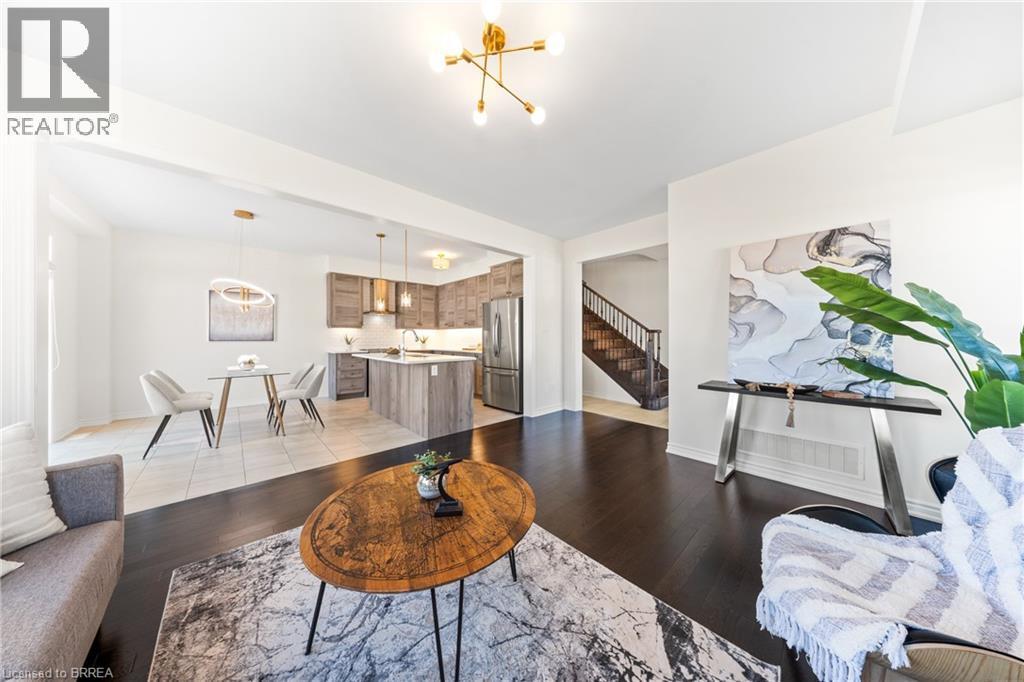 Living area featuring a chandelier, light wood-style floors, and stairs - 1 Bee Crescent, Brantford, ON