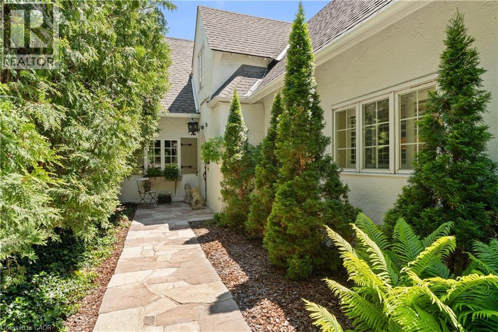 Flagstone walkway to front door. Cedar privacy hedge. Antique exterior coach lights. - 3040 First Street, Burlington, ON - Indoor Photo Showing Other Room