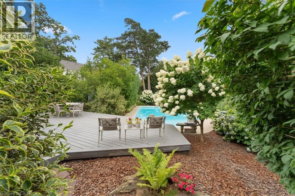 Large deck. Nikko blue hydrangea hedge. Extensive perennial plantings. Pink Weigela, Lime Light hydrangeas, ferns, honeysuckle, 2 large pines. Pine nugget pathway. - 3040 First Street, Burlington, ON - Indoor Photo Showing Dining Room